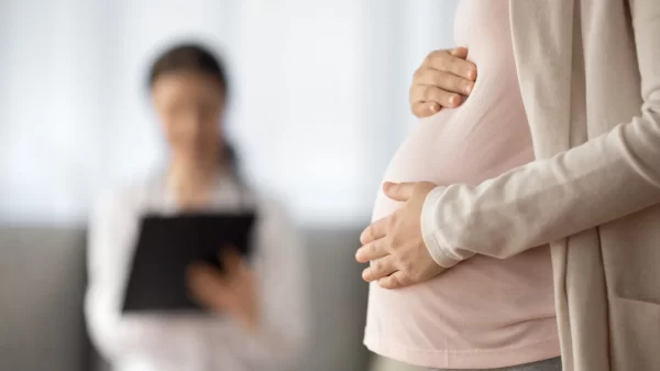 Close up of woman expecting baby having appointment with doctor