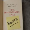 Title page inside a copy of The Handmaid's Tale by Margaret Atwood with a note saying "banned." The book has landed on many school and library banned book lists.