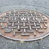 Sewer metal cap on the road in close up