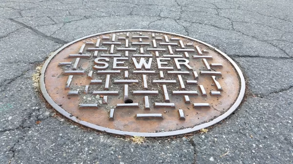 Sewer metal cap on the road in close up