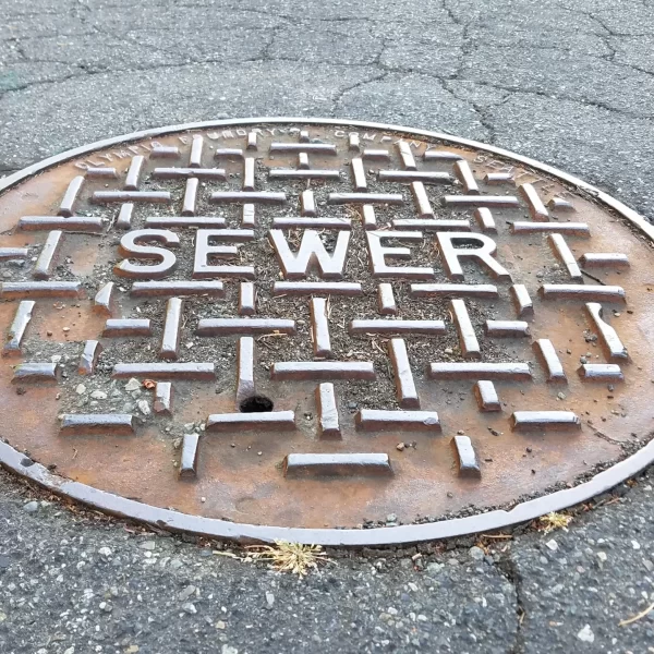 Sewer metal cap on the road in close up