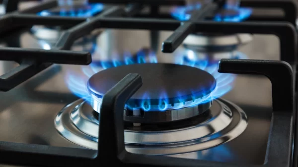 Stainless steel kitchen surface with cast-iron grill. Burning gas burners