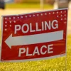 Election polling place yard sign with white text and red backgro