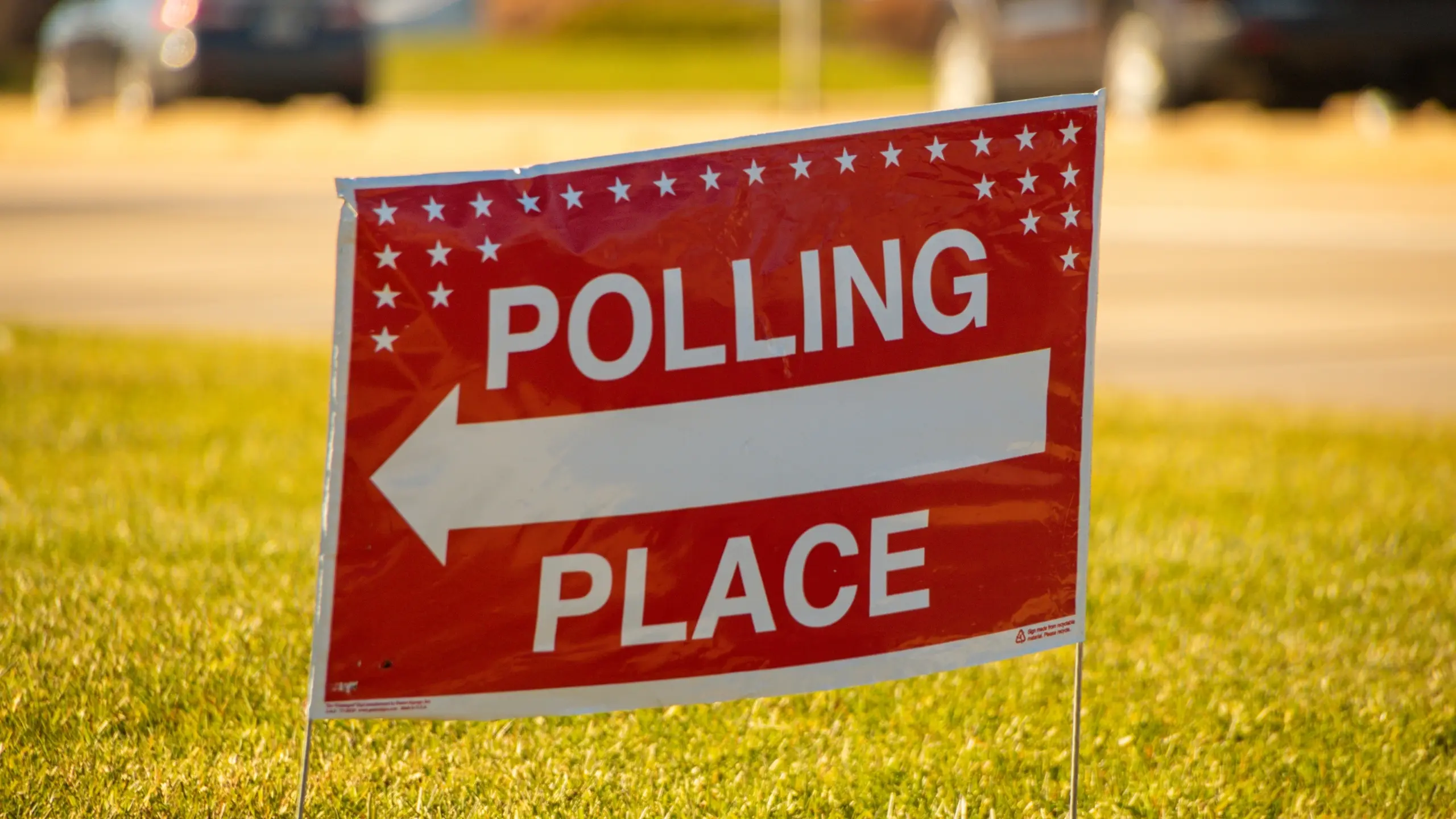 Election polling place yard sign with white text and red backgro