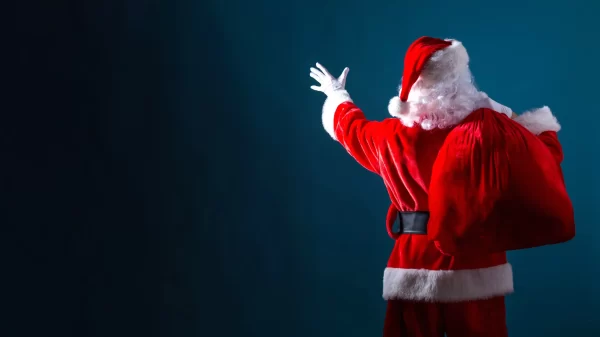 Santa holding a red sack on a dark blue background