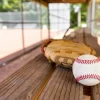 Baseball with glove on dugout bench with blurred background