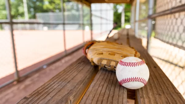 Baseball with glove on dugout bench with blurred background